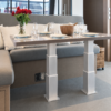 Electric table lift kit NL2388-PAIRE-TB installed in a yacht saloon - two synchronized 3-stage rectangular aluminium legs raising a dining table to full height in front of a U-shaped settee