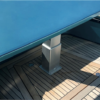 Electric table lift NL2389 installed in a yacht cockpit on a teak deck under a blue table top - 3-stage rectangular anodized aluminium pedestal 24V DC IP55